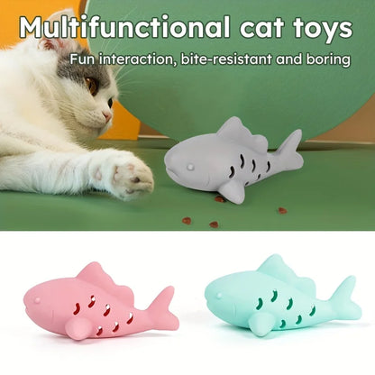 A playful cat interacting with interactive treat dispenser toy shark feeder, featuring bite-resistant design and fun colors.